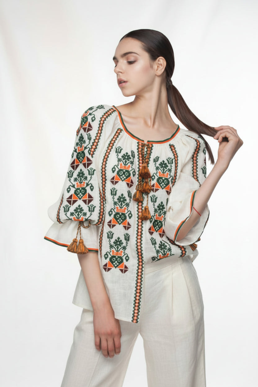 Woman wearing a white embroidered blouse with colorful patternsBLOUSE ROUMAINE SHOP