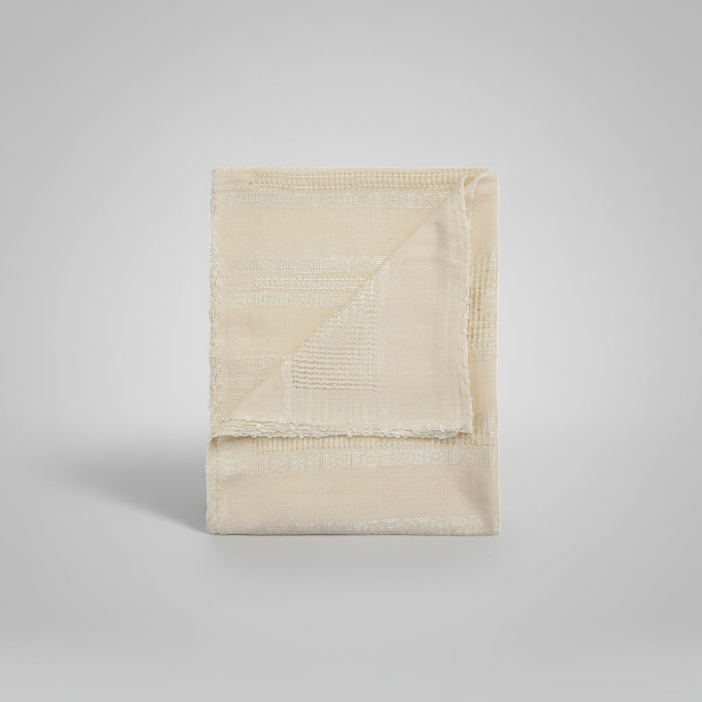 Folded beige blanket on a white background