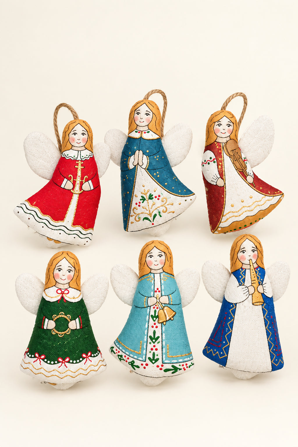 Six hand-painted felt Christmas angel ornaments in various traditional folkloric outfits, arranged on a split green and yellow background with pine branches.