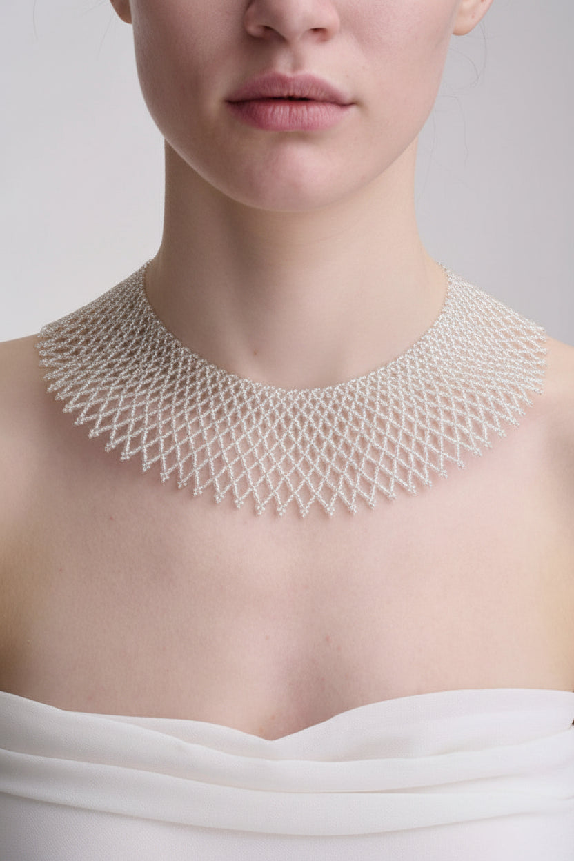 Close-up of a person wearing a detailed beaded necklace 