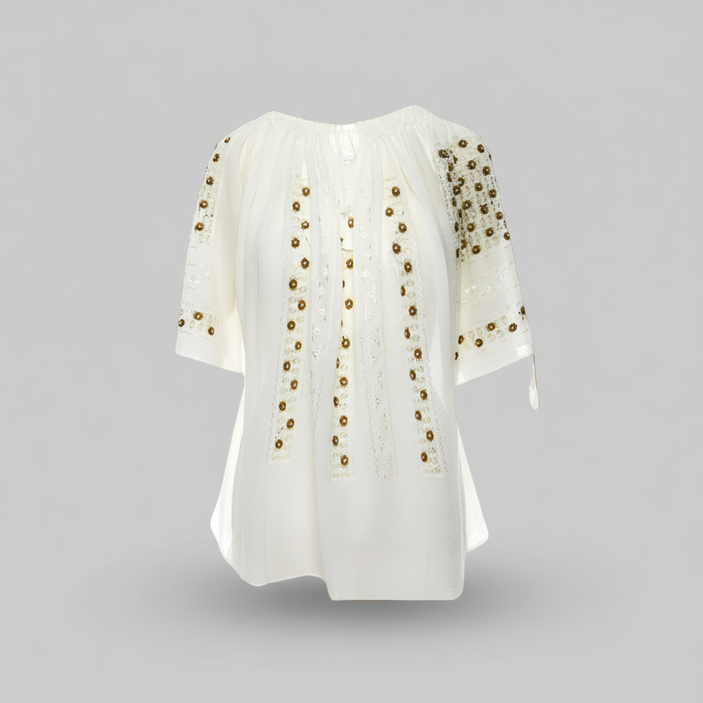 White blouse with gold embellishments on a brown background