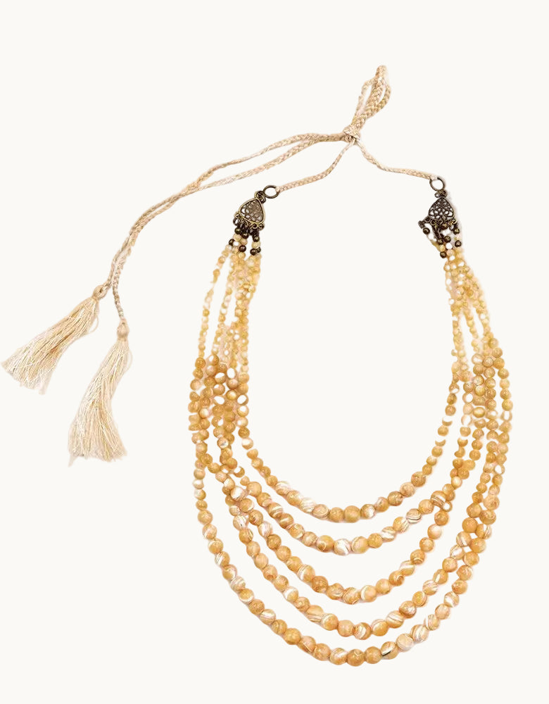 Multistrand pearl necklace with tassels on a white background