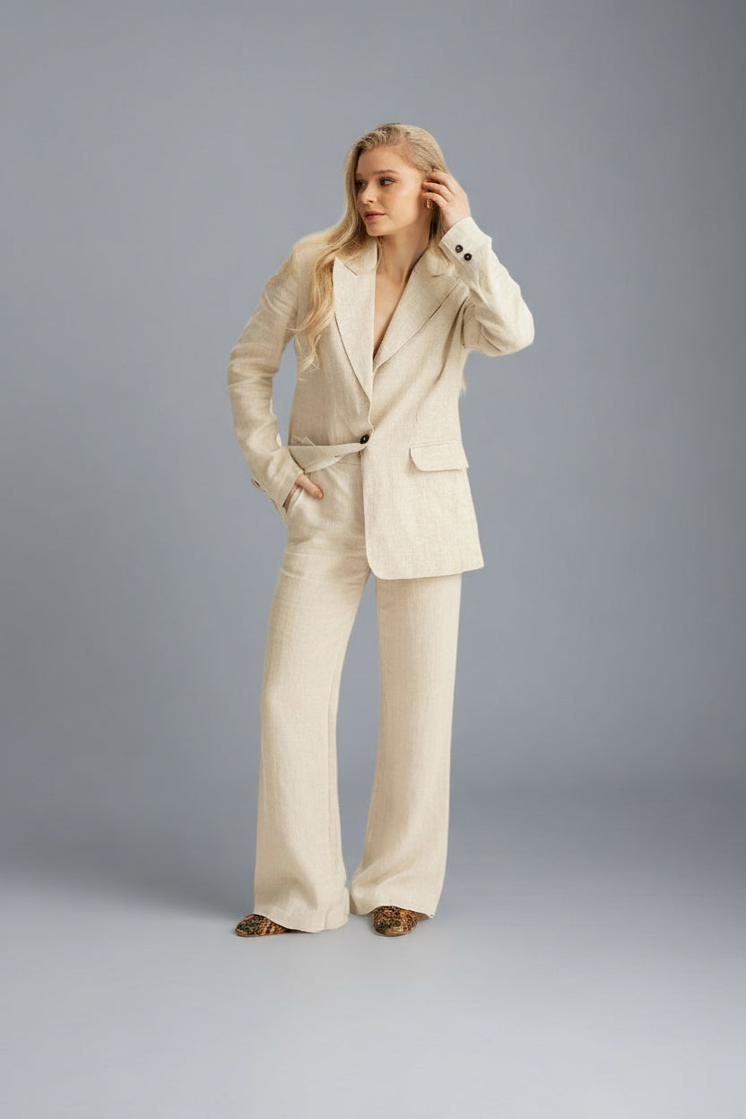 Woman wearing a beige suit against a gray background