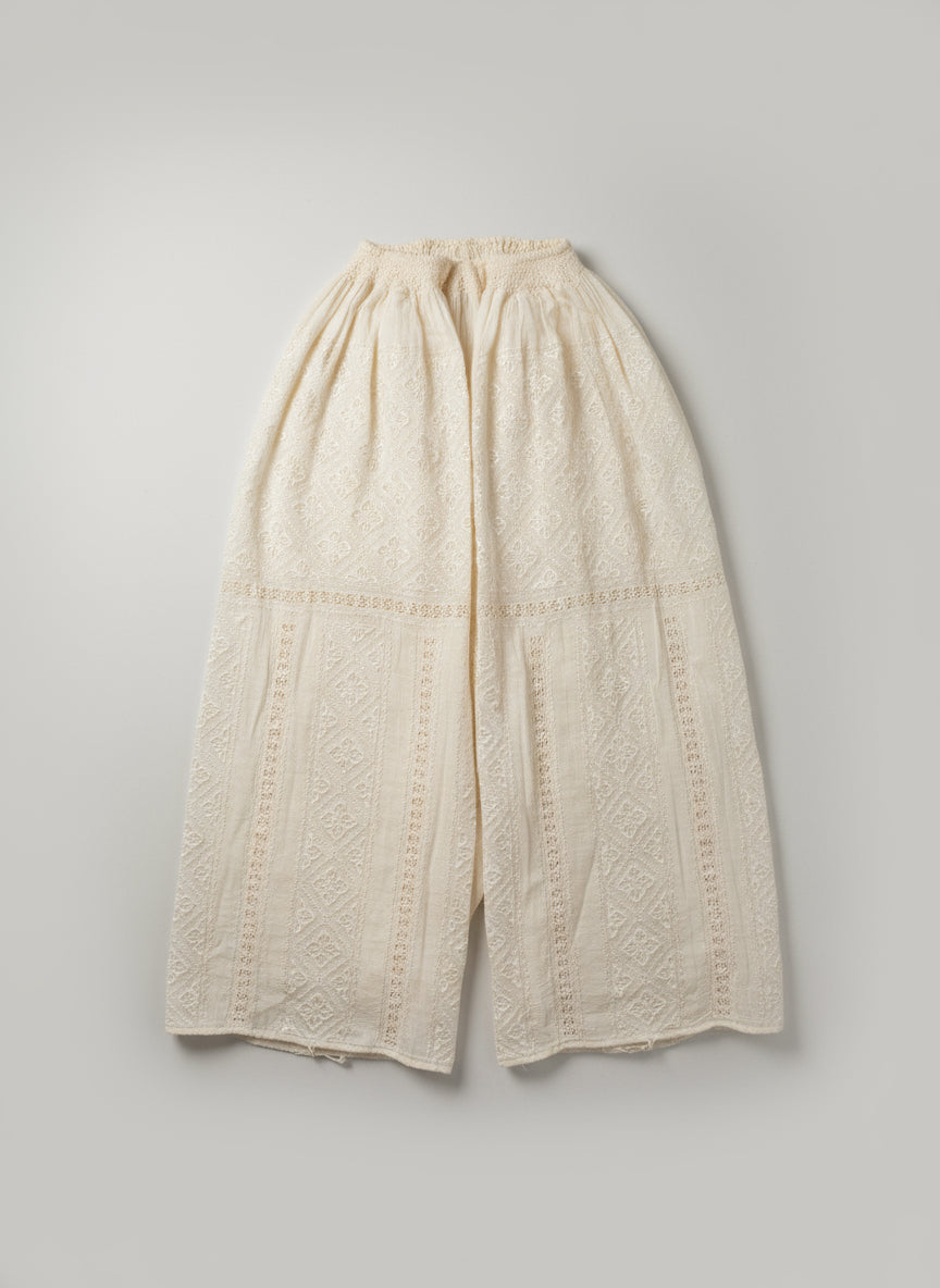 Beige lace top on a white fabric background
