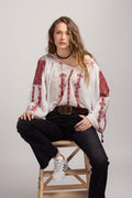 Woman wearing a white peasant  blouse with red embroidery,