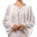 White lace top worn by a person on a white background