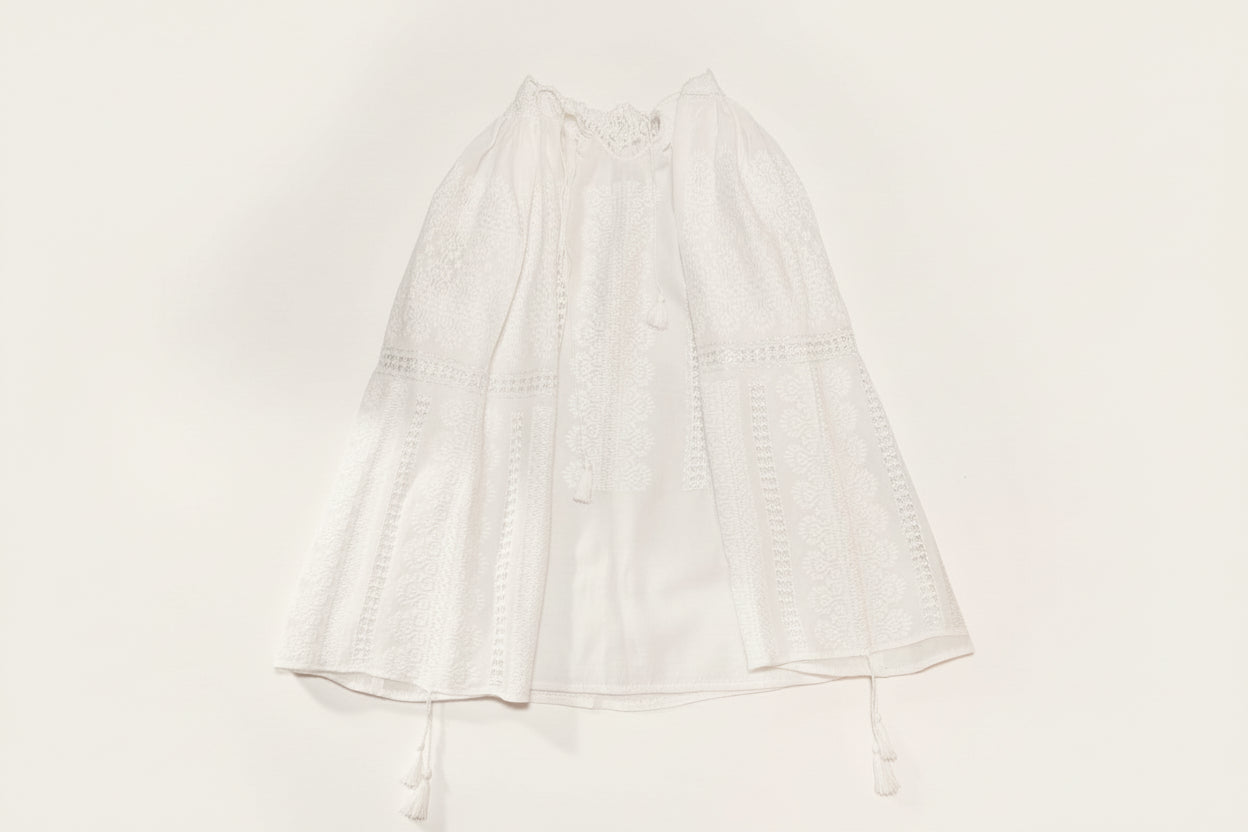 White embroidered Romanian Blouse  on a gray background