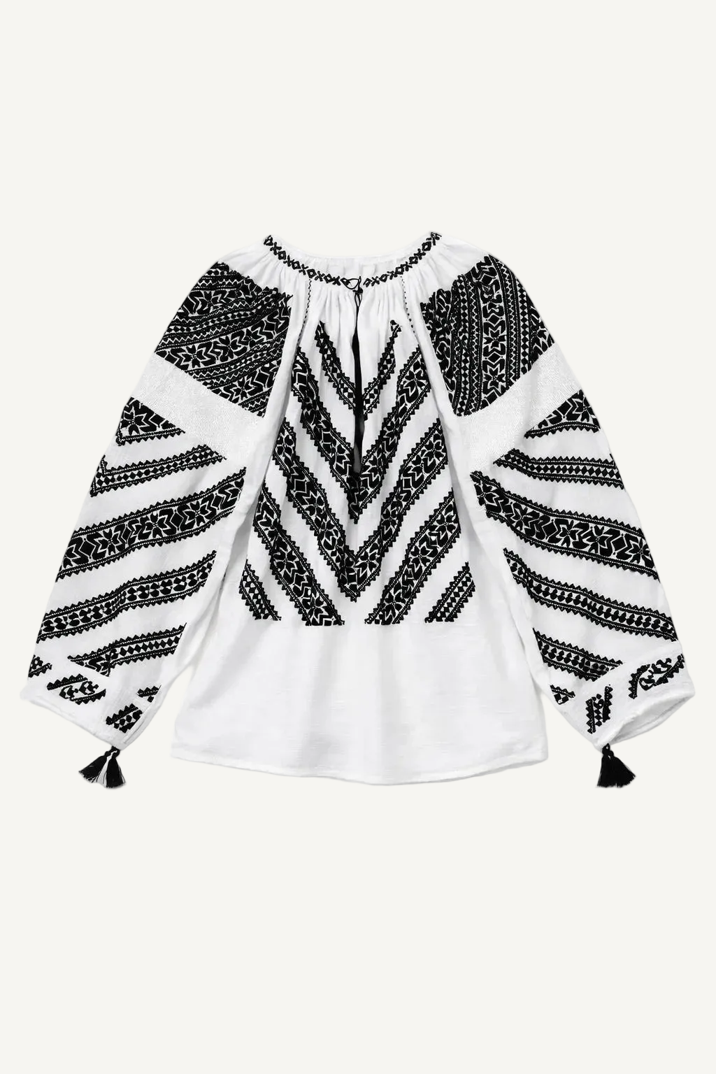 Black and white patterned blouse with long sleeves on a white background