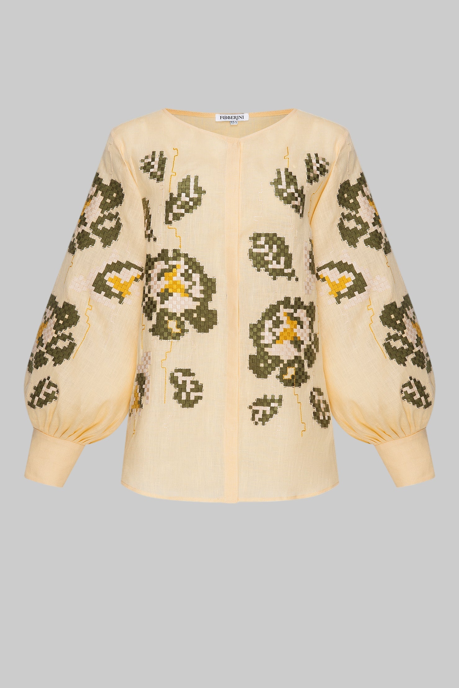 Beige blouse with green floral patterns on a white background