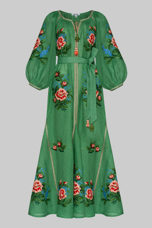 A long black linen dress with floral embroidery, three-quarter sleeves, and tassel ties at the neck.