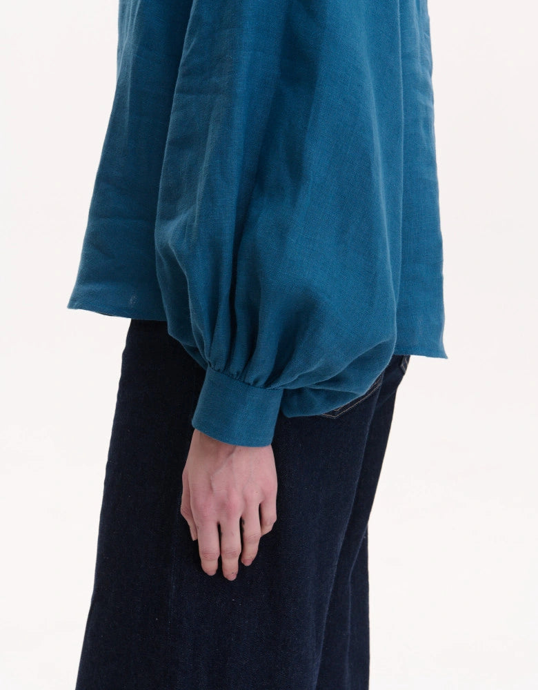 Teal blouse with puffed sleeves worn by a Bohemian linen blouse styled with jeans — Ukrainian heritage
