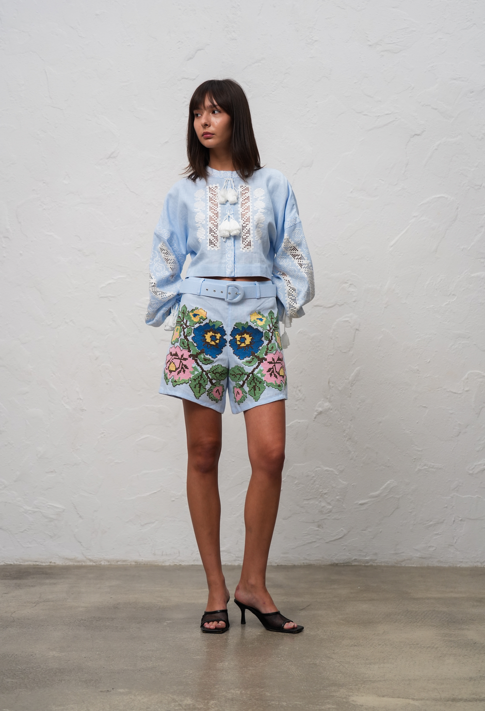 Hand-embroidered folk linen shorts in light blue – fabric detail