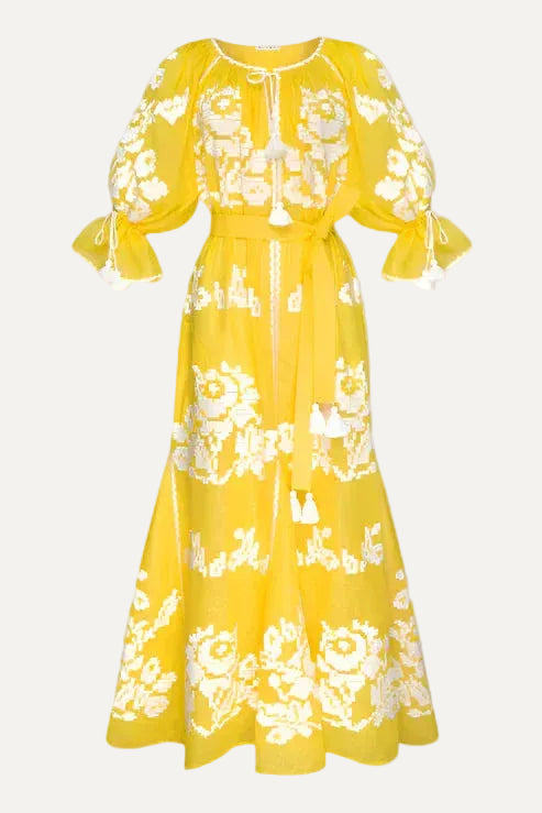Yellow dress with white floral embroidery on a gray background