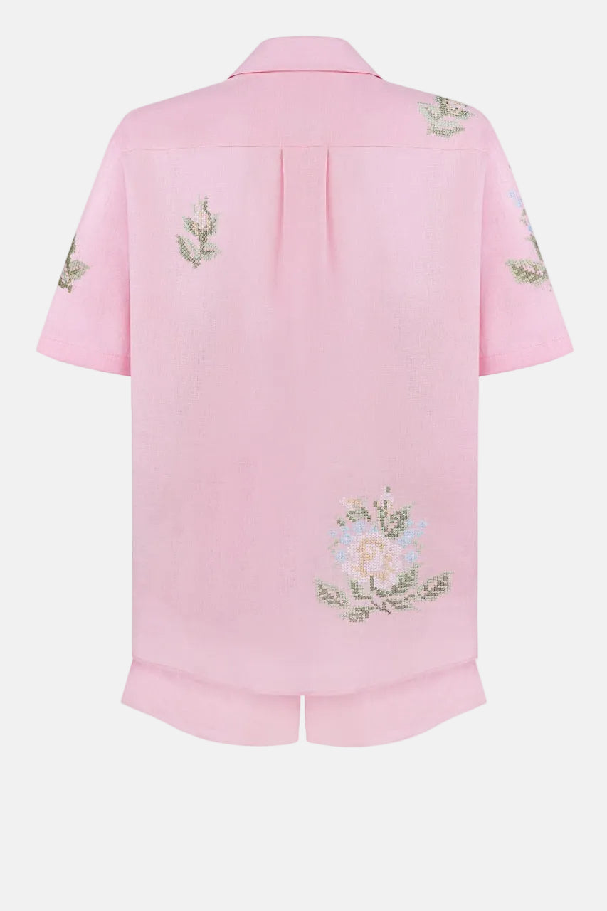 Pink shirt with floral embroidery on a white background