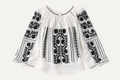 White blouse with black floral embroidery on a white background