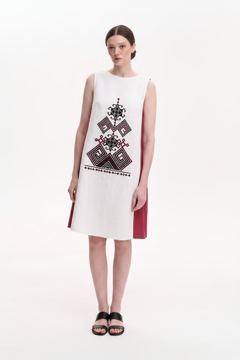 Woman wearing a sleeveless dress with geometric pattern on a white background