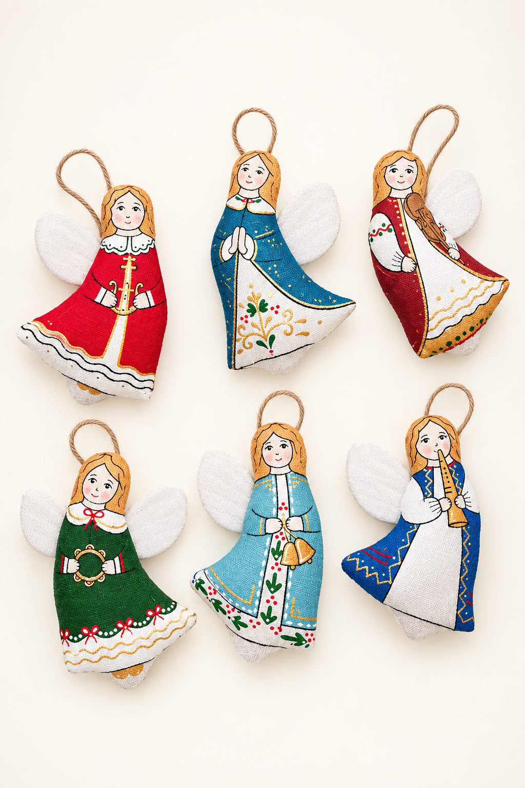 Six hand-painted felt Christmas angel ornaments in various traditional folkloric outfits, arranged on a split green and yellow background with pine branches.