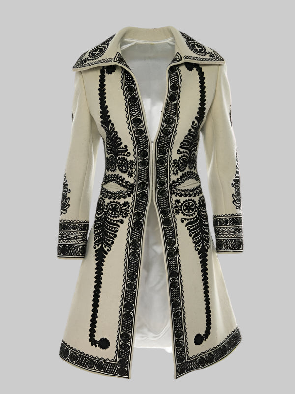 Ecru coat with black embroidered patterns, long sleeves, and a Peter Pan collar.