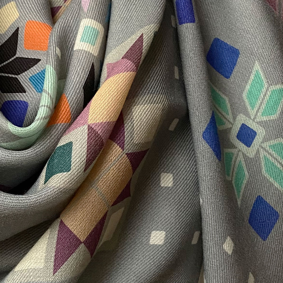 Close-up of textured fabric with geometric patterns in various colors.