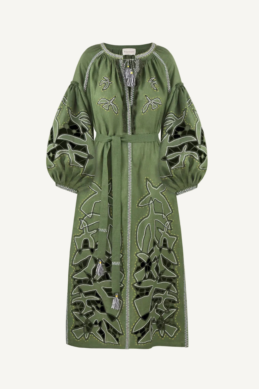 Green dress with intricate white embroidery on a white background