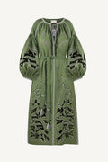 Green dress with intricate white embroidery on a white background