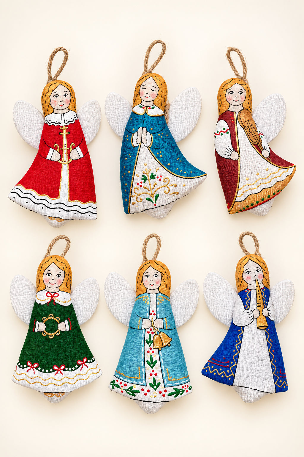 Six hand-painted felt Christmas angel ornaments in various traditional folkloric outfits, arranged on a split green and yellow background with pine branches.
