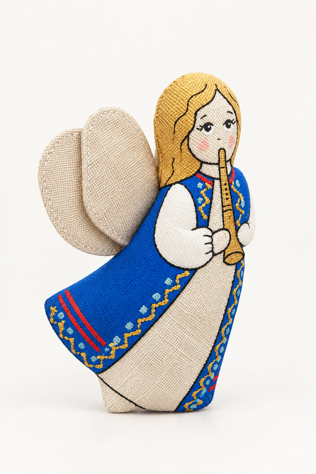 A handmade embroidered fabric angel ornament with blonde hair, a blue and white dress, and beige wings, shown against a blurred snowy outdoor background.