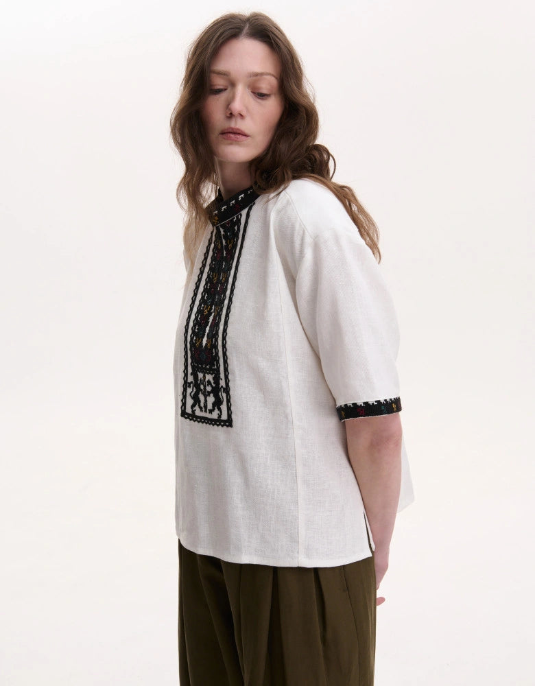 Hand-stitched lion motif embroidery on natural fabric vyshyvanka tunic