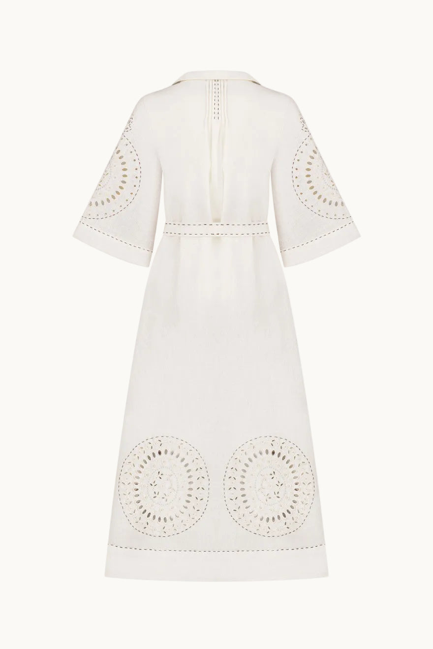 An off-white midi dress with intricate circular eyelet embroidery on the sleeves, waist, and hem, shown from the back against a plain white background.