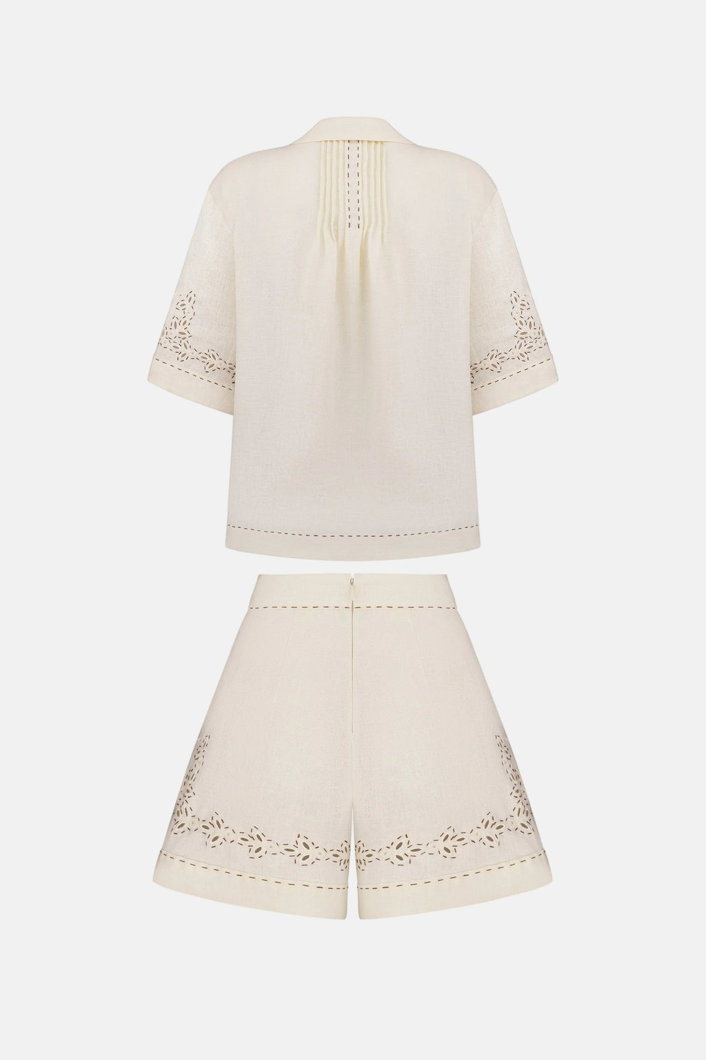 White outfit with embroidered details on a white background