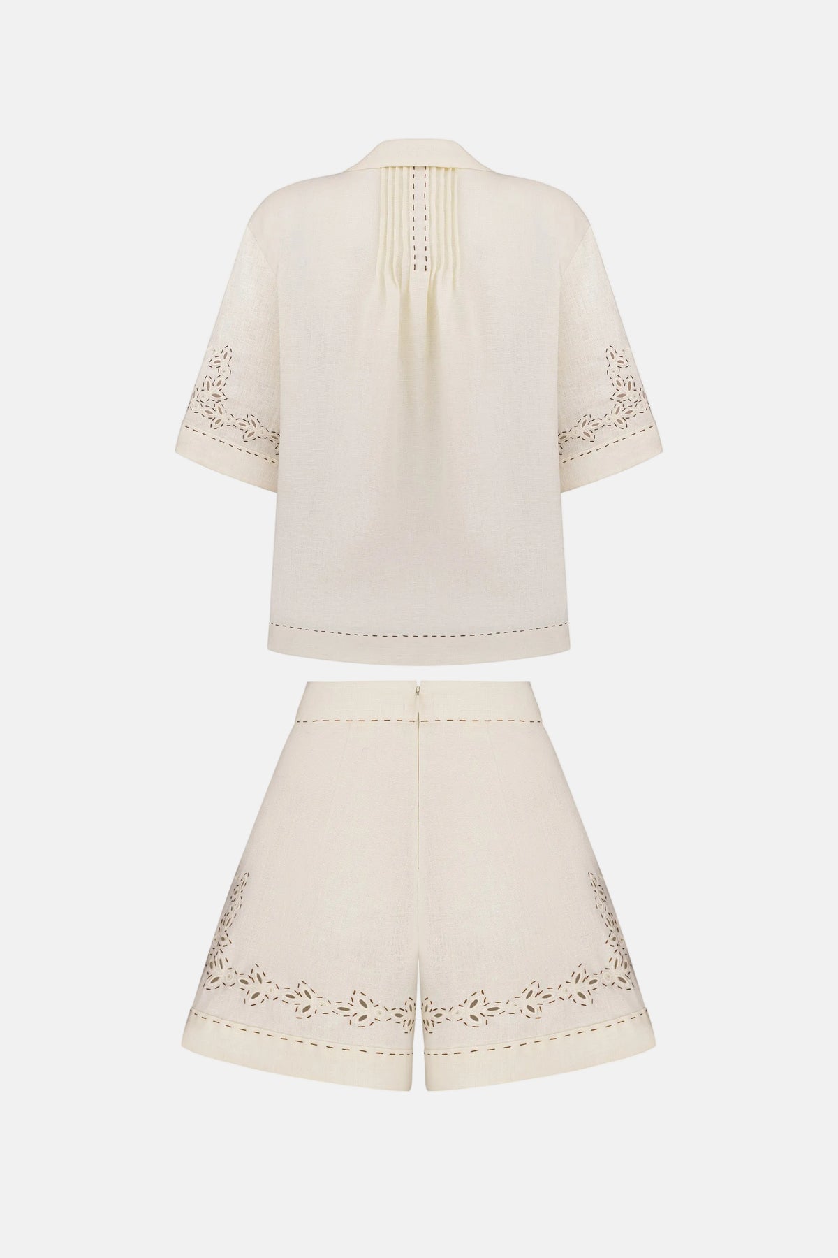 White outfit with embroidered details on a white background
