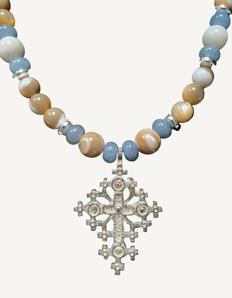 Necklace with beaded chain and Ethiopian cross pendant on a black background