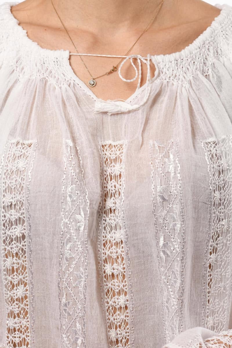 Close-up of a white lace blouse with intricate detailing.
